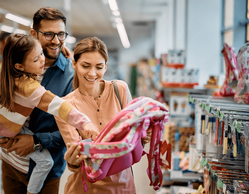 Familia eligiendo una mochila para su hija para la vuelta al cole